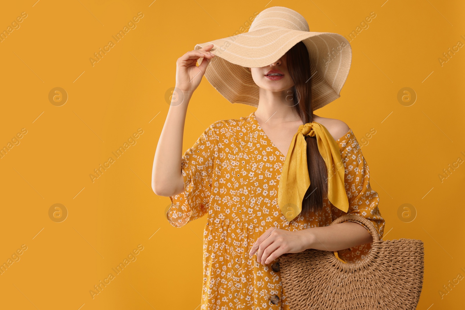 Photo of Woman with hat and stylish bandana on yellow background