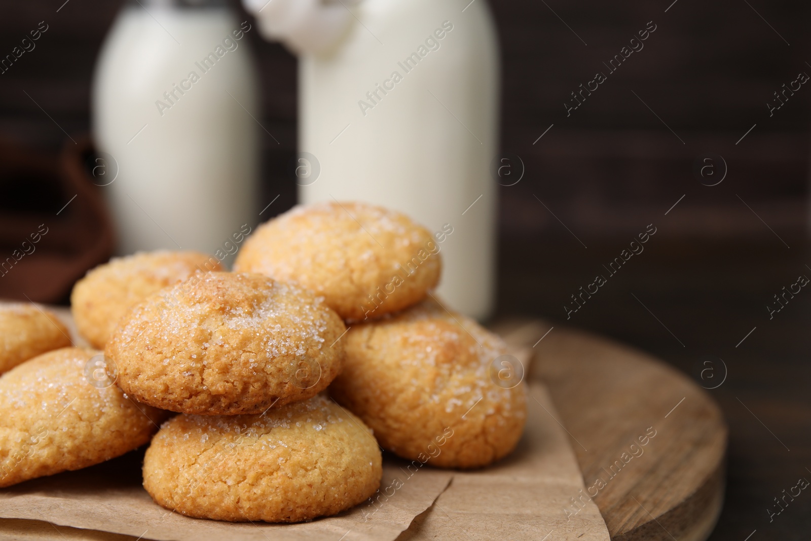 Photo of Tasty sweet sugar cookies and milk on wooden table, closeup