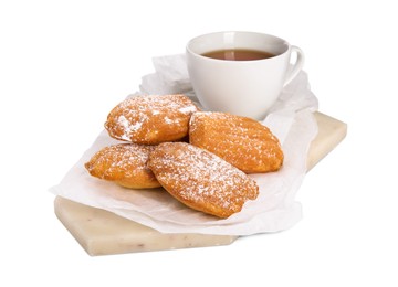 Photo of Delicious madeleine cakes with powdered sugar and tea on white background