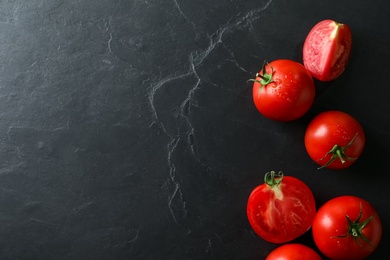 Fresh ripe tomatoes on black table, flat lay. Space for text