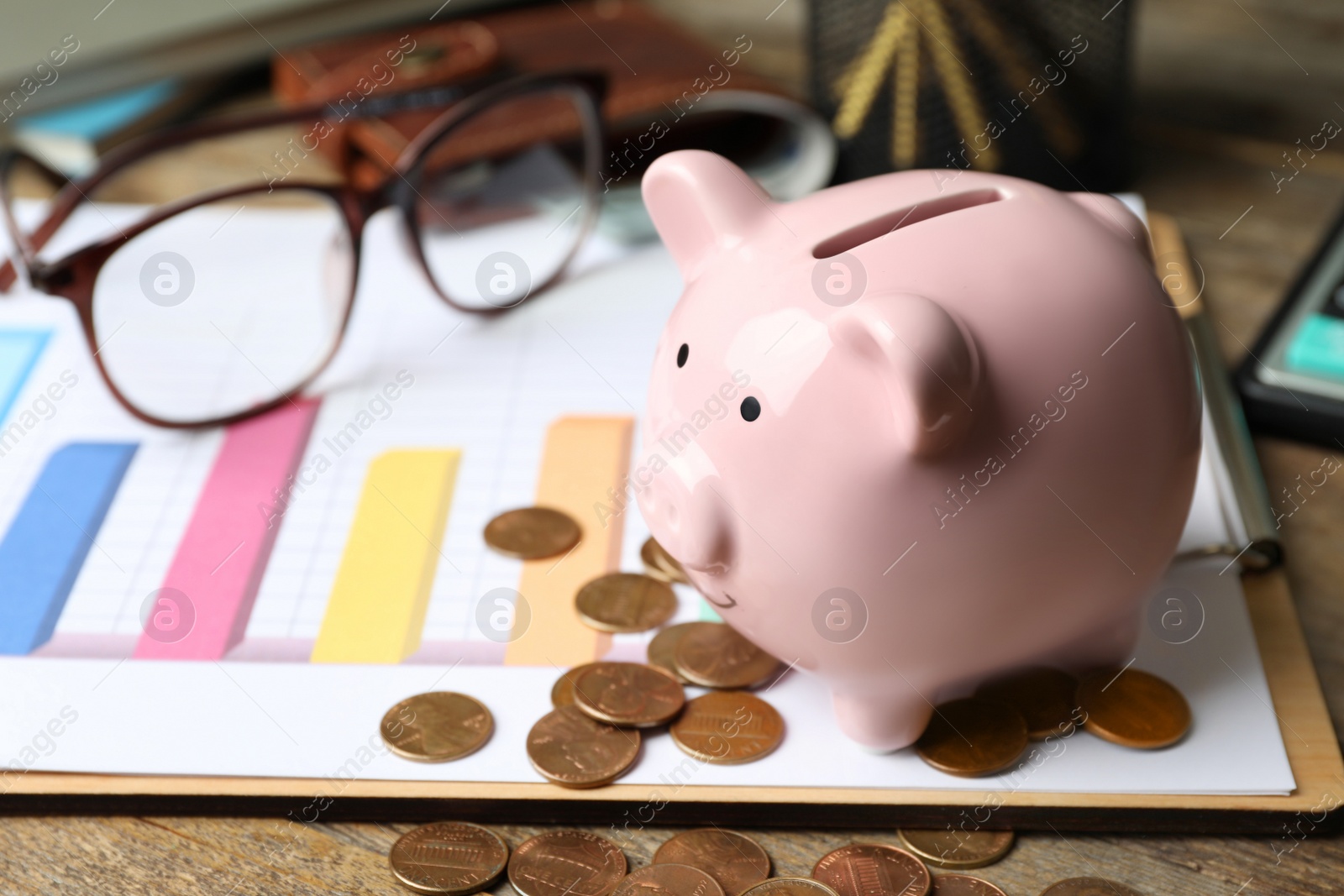 Photo of Piggy bank and money on wooden table, space for text