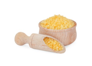 Photo of Bowl and scoop with yellow sea salt isolated on white