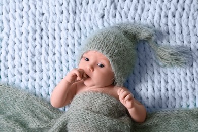 Photo of Cute newborn baby on light blue blanket, top view