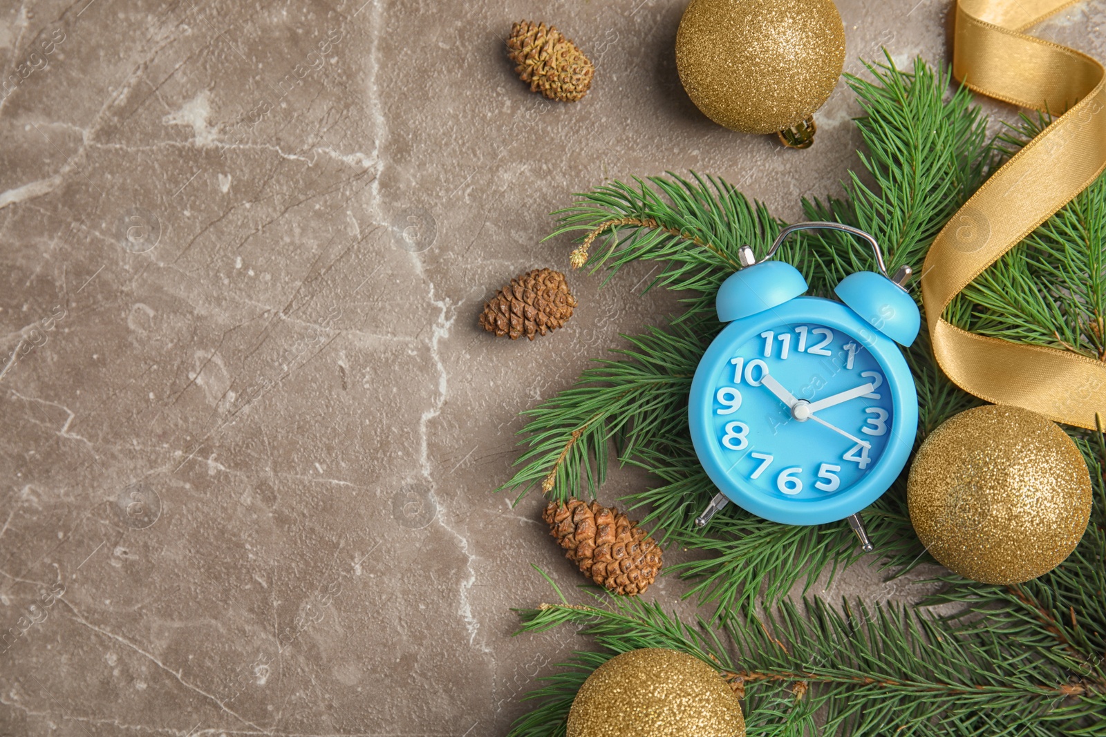 Photo of Flat lay composition with alarm clock, fir branches and decorations on grey background. Christmas countdown