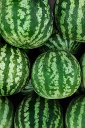 Delicious ripe watermelons as background, top view