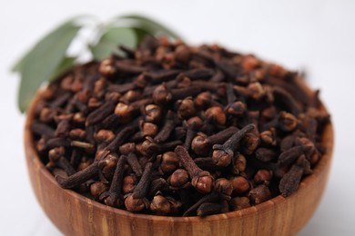 Photo of Aromatic cloves in bowl on table, closeup