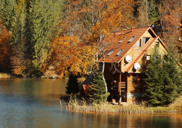 Beautiful landscape with country house near forest and river on sunny day