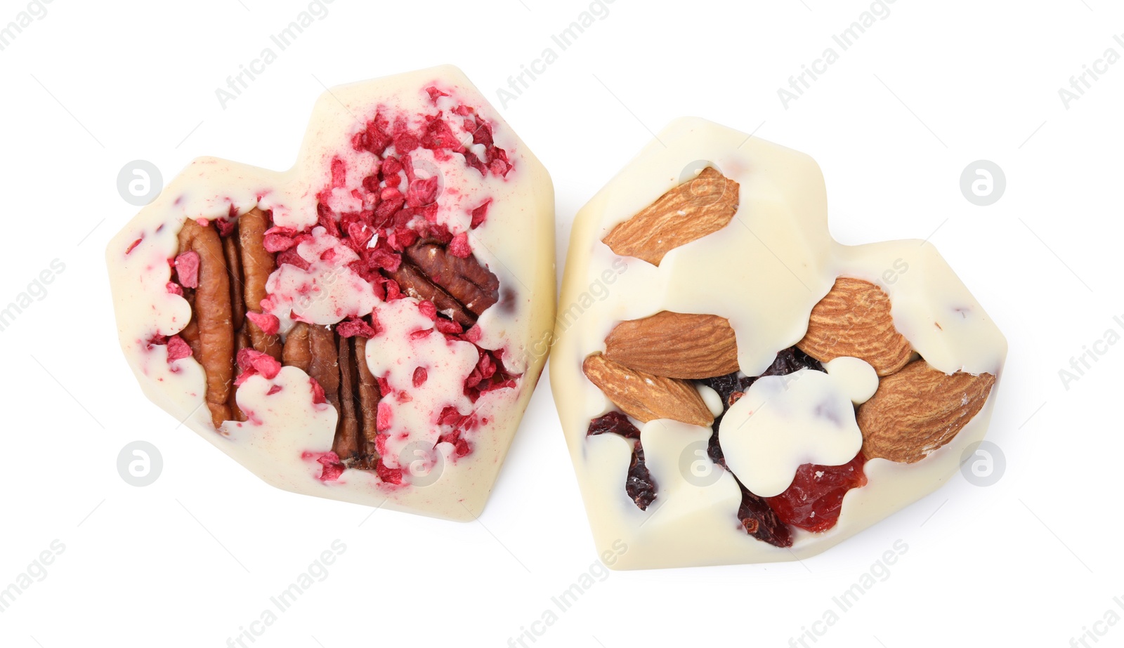 Photo of Tasty chocolate heart shaped candies with nuts on white background, top view