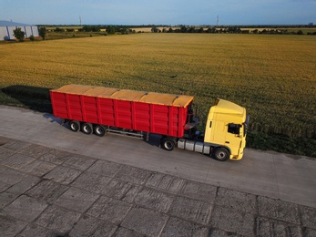 Photo of Modern bright truck on road near wheat field