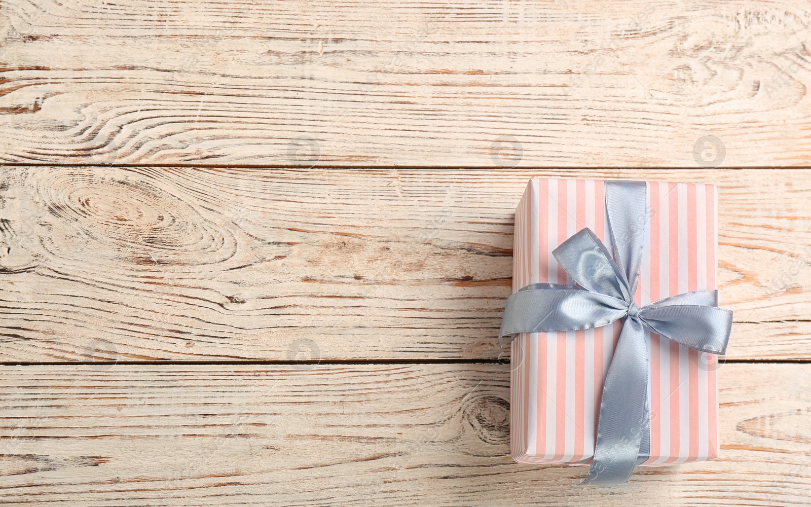 Photo of Elegant gift box with bow on wooden background, top view