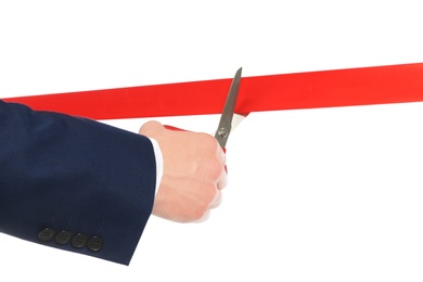 Photo of Man in office suit cutting red ribbon isolated on white, closeup