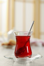 Glass of traditional Turkish tea on white wooden table indoors