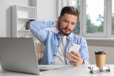 Man using smartphone while working in office