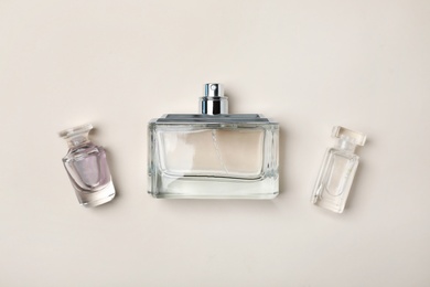 Photo of Bottles of perfume on light background, top view