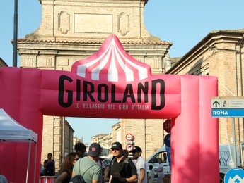 Photo of JESI, ITALY - MAY 17, 2022: People under inflatable arch on city street. Stage 10 of Giro d`Italia 105 bicycle race