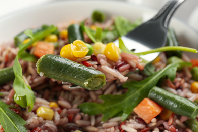 Photo of Tasty brown rice with vegetables, closeup view