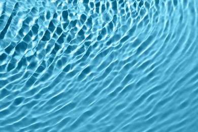 Rippled surface of clear water on light blue background, top view