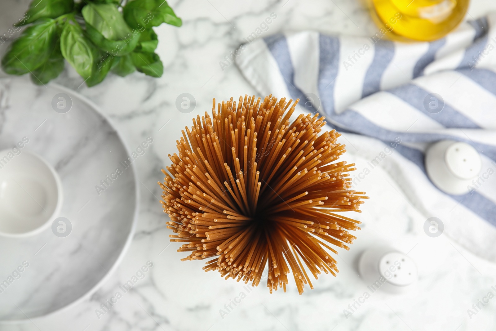 Photo of Uncooked buckwheat noodles on white marble table, flat lay