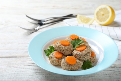 Plate of traditional Passover (Pesach) gefilte fish on wooden background