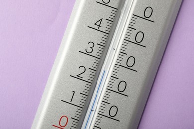 Photo of Modern weather thermometer on lilac background, closeup