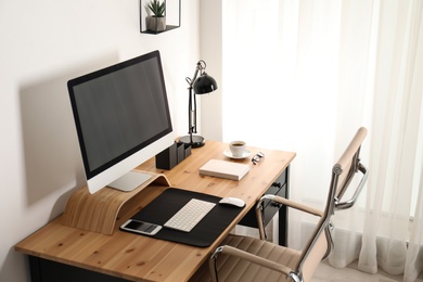 Photo of Stylish workplace interior with modern computer on table. Mockup for design