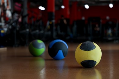 Photo of Medicine balls on floor in gym. Space for text