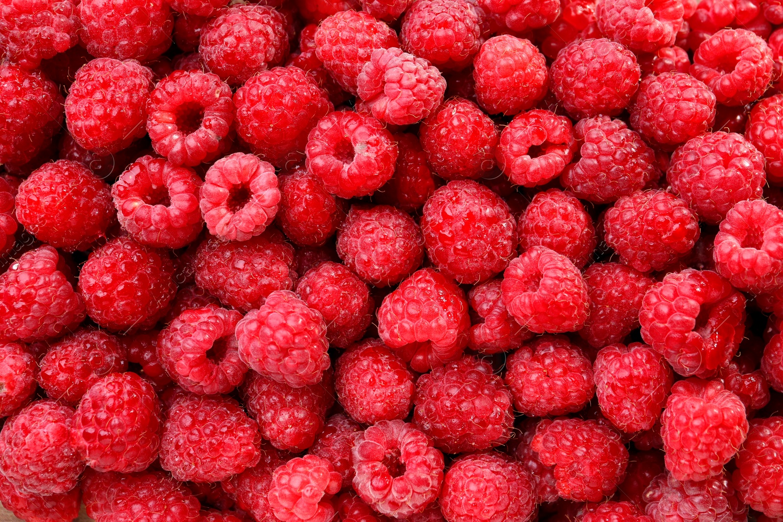 Photo of Heap of tasty ripe raspberries as background, top view