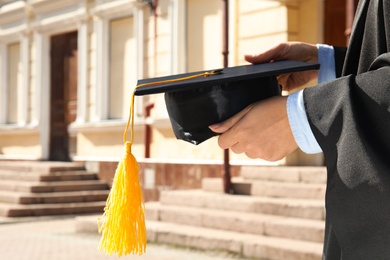 Student with graduation hat outdoors on sunny day, closeup