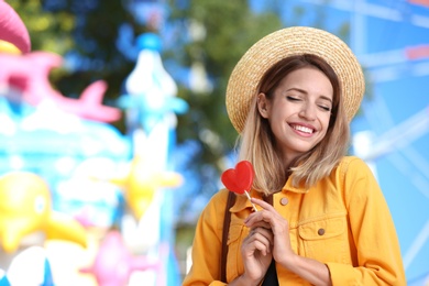 Beautiful woman with candy having fun at amusement park