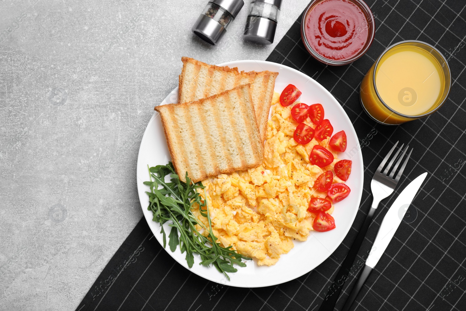 Photo of Delicious scrambled eggs served on light grey table, flat lay