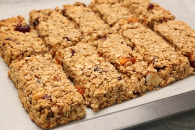 Photo of Many tasty granola bars on baking tray, closeup