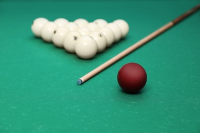 Photo of Different billiard balls and cue on table