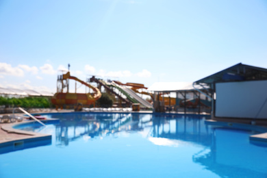 Photo of Blurred view of water park with swimming pool. Summer vacation