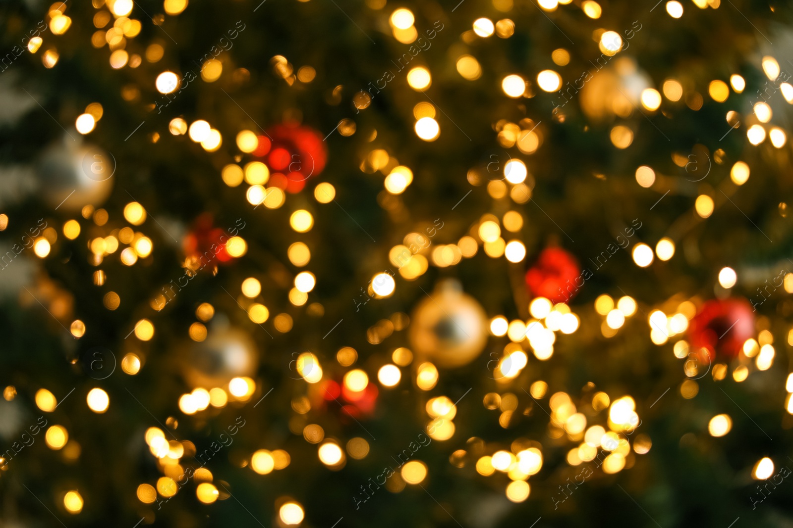 Photo of Blurred view of Christmas tree with bright fairy lights and ornaments, closeup. Bokeh effect