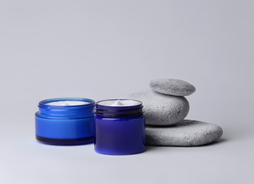 Photo of Jars of body cream on light background