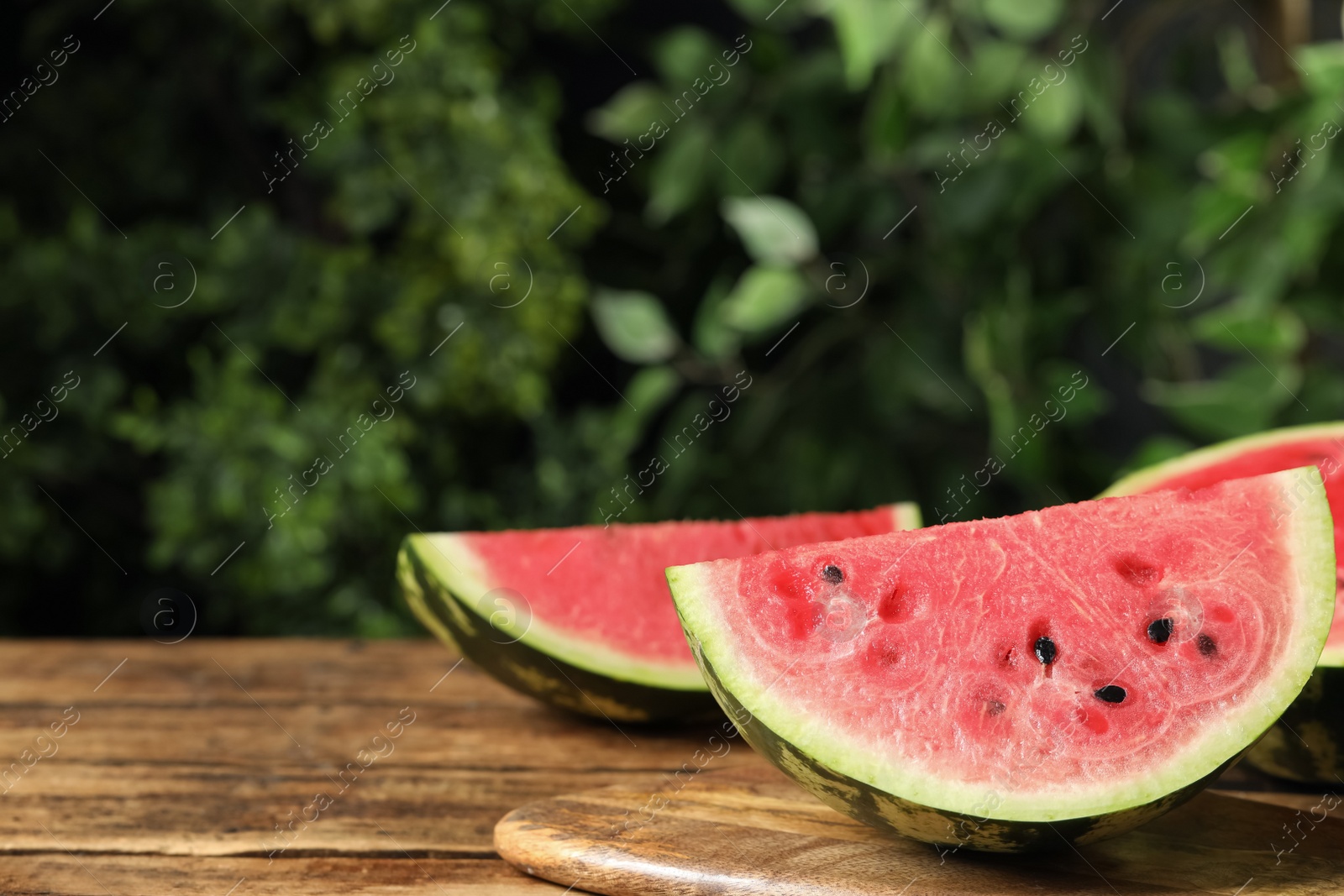 Photo of Delicious fresh watermelon slices on wooden table. Space for text