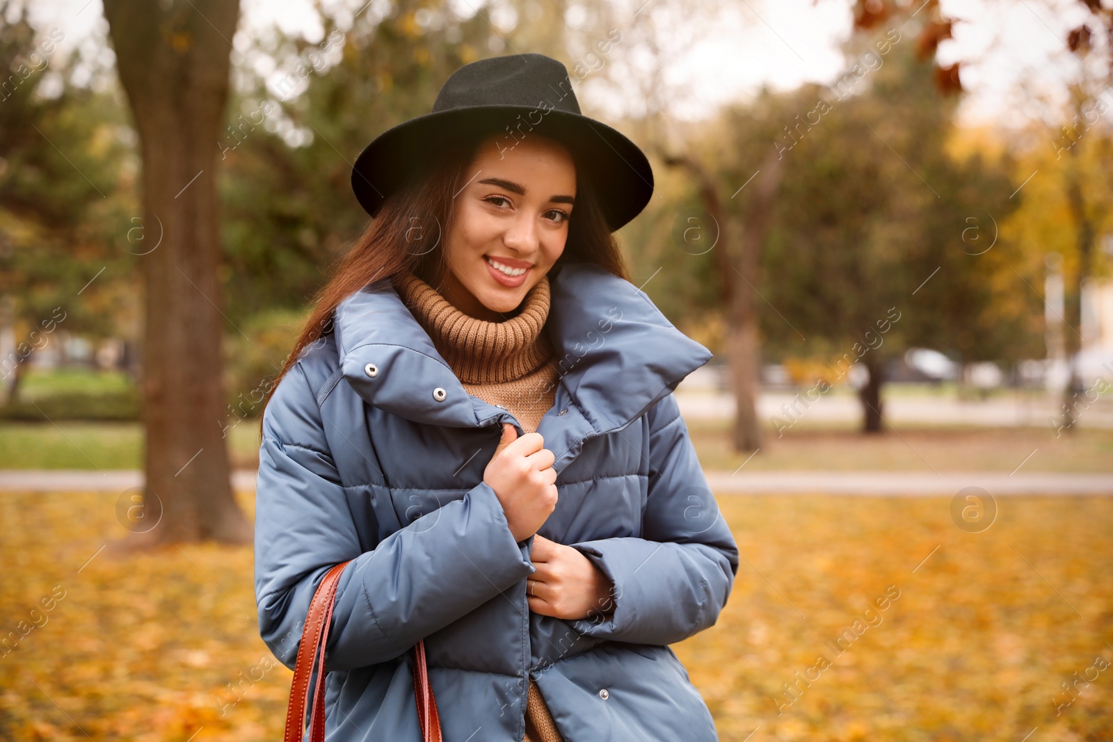 Photo of Young woman wearing stylish clothes in autumn park