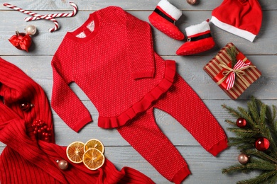 Flat lay composition with cute Christmas baby clothes on grey wooden background