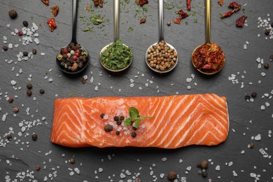 Photo of Fresh salmon and ingredients for marinade on black table, flat lay