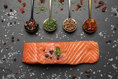 Fresh salmon and ingredients for marinade on black table, flat lay