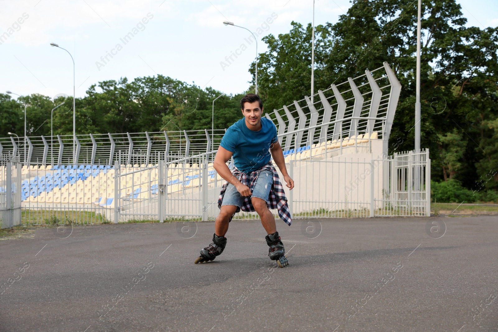 Photo of Handsome young man roller skating outdoors. Recreational activity