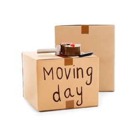 Photo of Moving boxes, marker and adhesive tape dispenser on white background