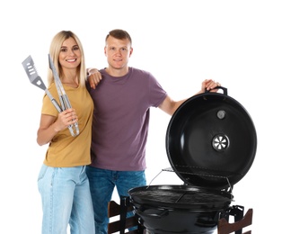 Happy couple with barbecue grill and utensils on white background