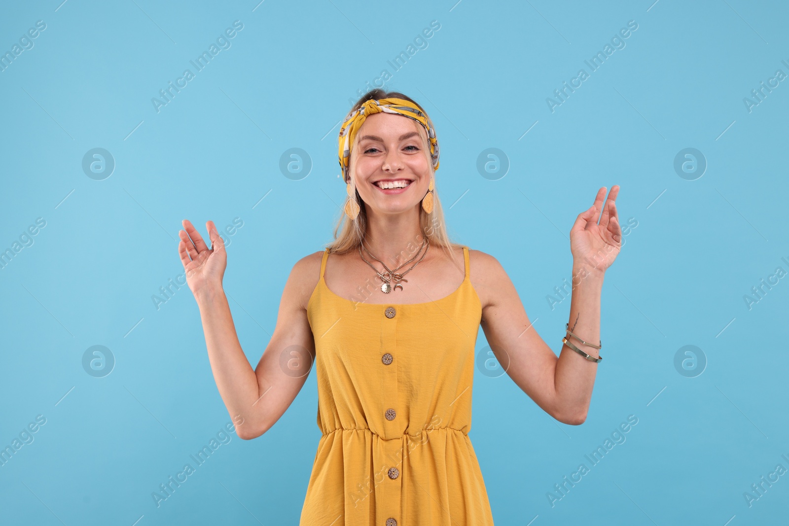 Photo of Portrait of smiling hippie woman on light blue background