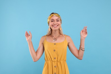 Photo of Portrait of smiling hippie woman on light blue background