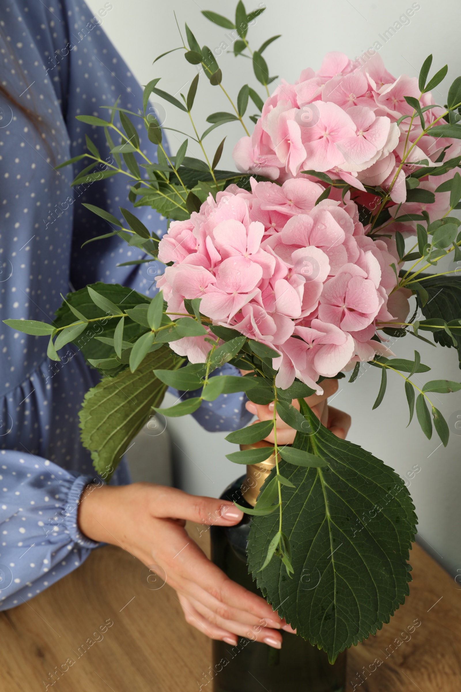 Photo of Woman with bouquet of beautiful hortensia flowers indoors, closeup