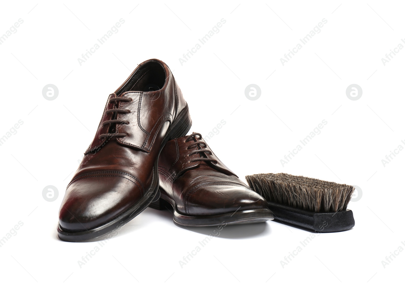 Photo of Stylish men's shoes and cleaning brush on white background