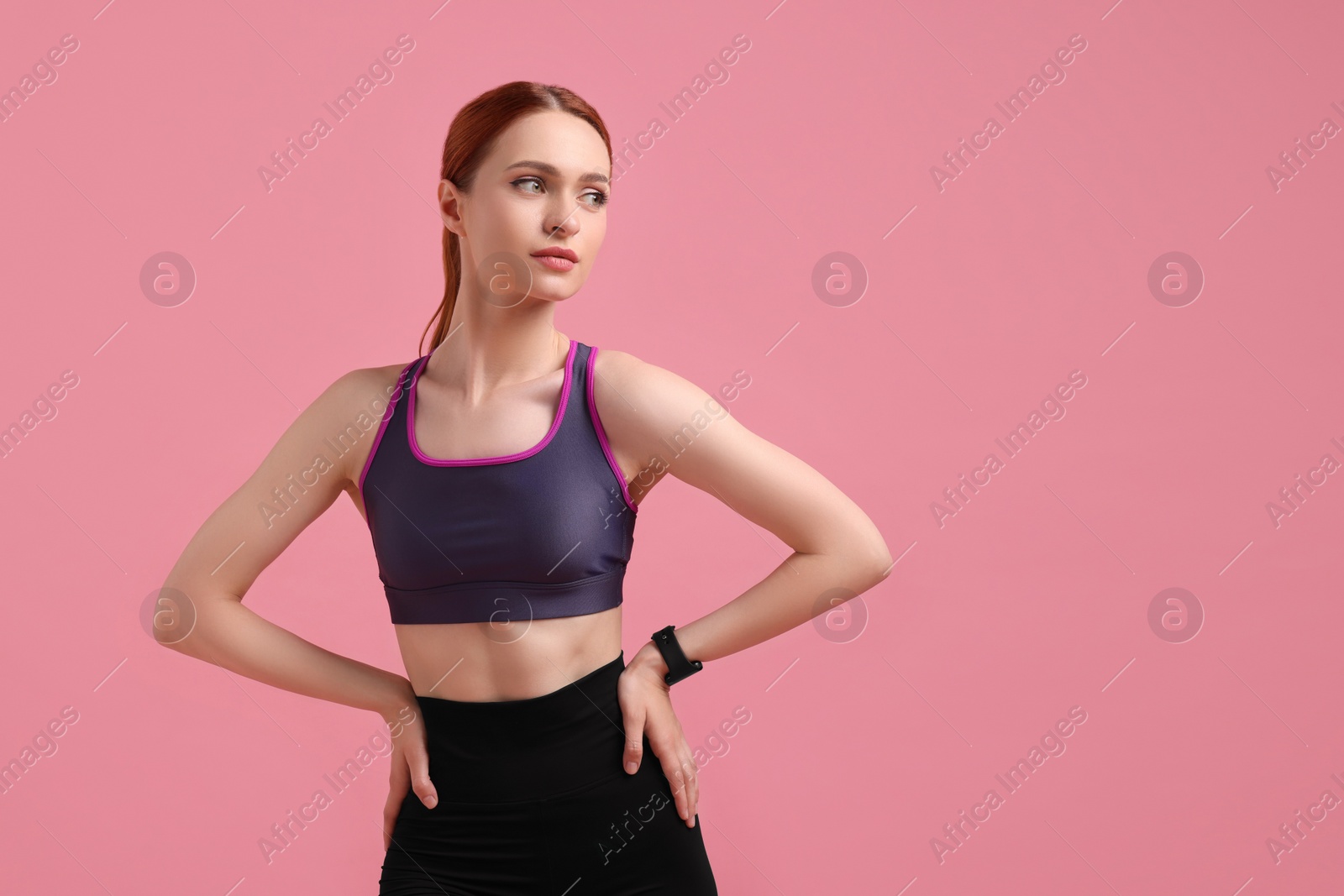 Photo of Young woman in sportswear on pink background, space for text