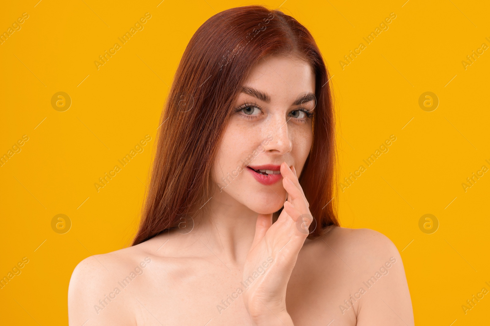 Photo of Portrait of beautiful woman with freckles on yellow background