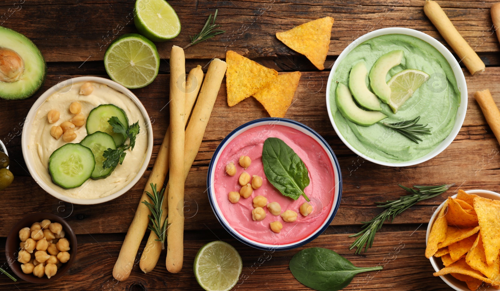 Photo of Flat lay composition with delicious hummuses on wooden table